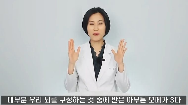 흰 가운을 입은 의사가 두 손을 들어 보이며 설명하는 장면. 화면 아래 자막: 대부분 우리 뇌를 구성하는 것 중에 반은 오메가3다